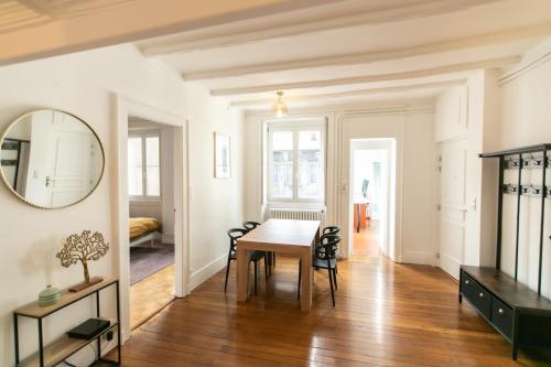 une salle à manger avec une table et un miroir dans l'établissement Appartement Haussmannien Centre Ville, à Besançon