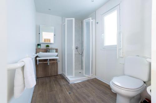 a white bathroom with a toilet and a shower at Club del Sole Adriatico Cervia Easy Camping Village in Cervia