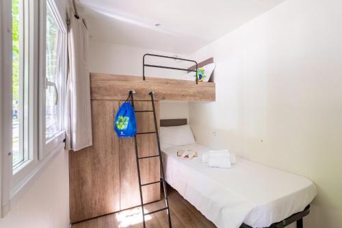 a small room with a bunk bed and a ladder at Club del Sole Adriatico Cervia Easy Camping Village in Cervia