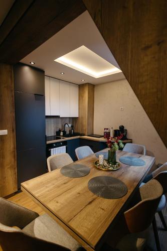 a dining room table with chairs and a kitchen at BOROVI PRESIDENT SPA Apartment in Divčibare