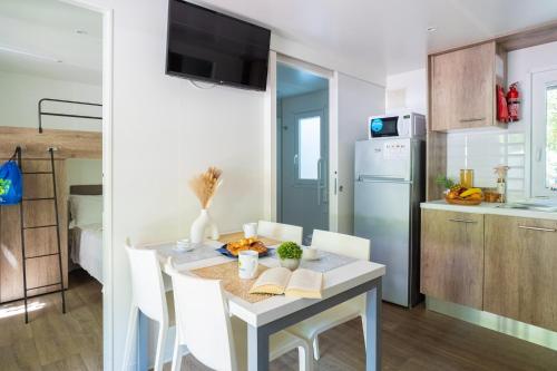 a kitchen and dining room with a table and chairs at Club del Sole Adriatico Cervia Easy Camping Village in Cervia