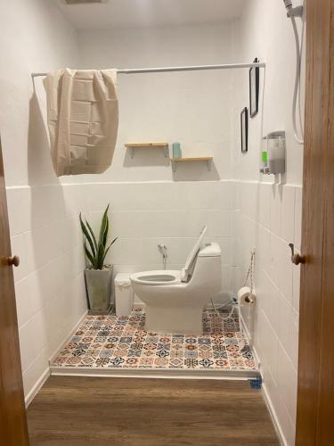 a bathroom with a toilet on a tiled floor at De Hope Kohlanta in Ko Lanta Yai