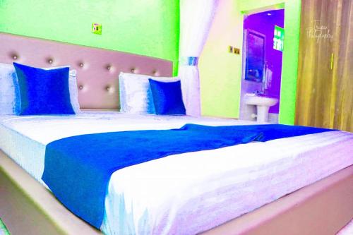 ein Schlafzimmer mit einem großen Bett mit blauen und weißen Kissen in der Unterkunft Ten villa luxury resort in Lodwar