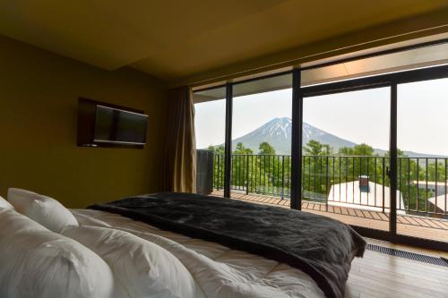 a bedroom with a bed with a view of a mountain at MUSE Niseko in Kutchan