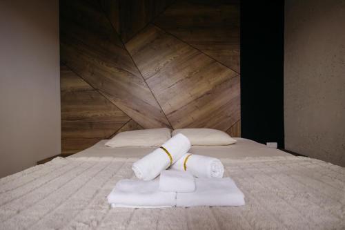a bed with two rolls of towels on it at BOROVI PRESIDENT SPA Apartment in Divčibare
