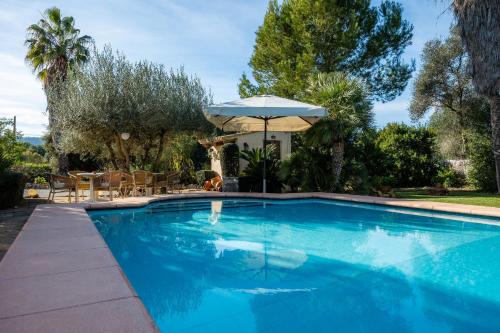 a large blue swimming pool with an umbrella at Can Bleo in Pollença
