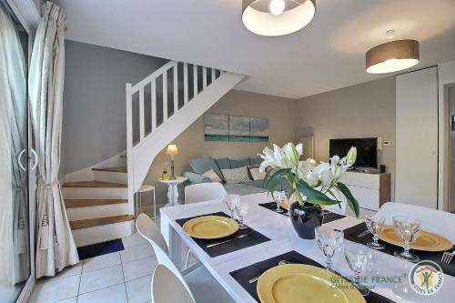 une salle à manger et un salon avec une table et des chaises dans l'établissement Maison six, à Pléneuf-Val-André