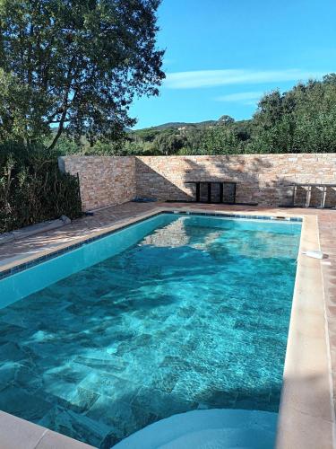 une piscine avec de l'eau bleue dans une cour dans l'établissement Villa Norgreen 4, à Grimaud