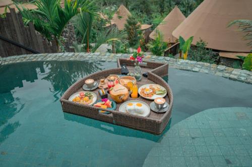 a tray of food on a table in the water at The Wapa Lux Tent in Sidemen