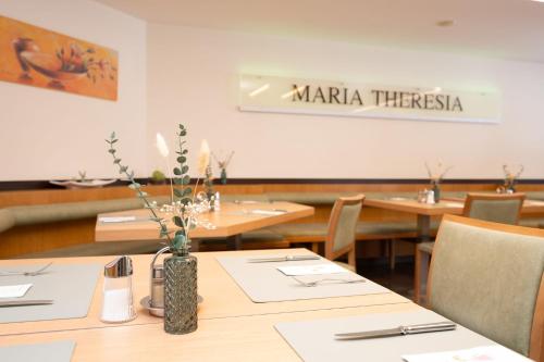 a dining room with wooden tables and a vase with flowers at Hotel Garni Maria Theresia in Sölden