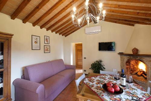 sala de estar con sofá, mesa y chimenea en Podere Bagnoli, en Castagneto Carducci