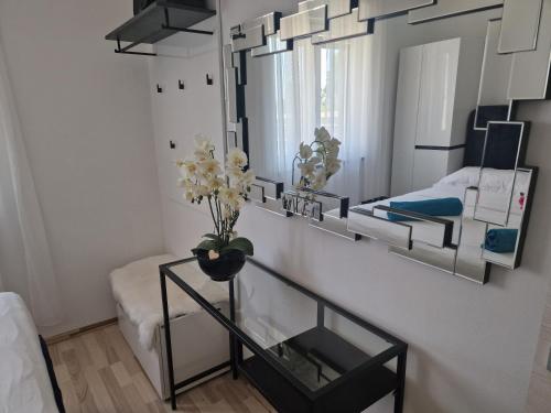 クルニカにあるHaus Milly Jacuzzi & Poolの鏡と花のテーブルが備わる部屋