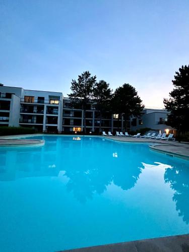 a large blue swimming pool in front of a building at Apartmán NAUTIS in Piešťany