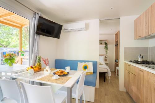 a kitchen and dining room with a table and chairs at Club del Sole Adriatico Cervia Easy Camping Village in Cervia