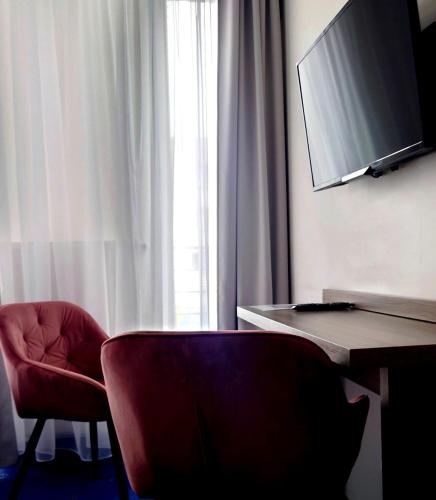 a room with a red chair and a desk and a window at Willa Długa No. 4 Bed & Breakfast in Gdynia