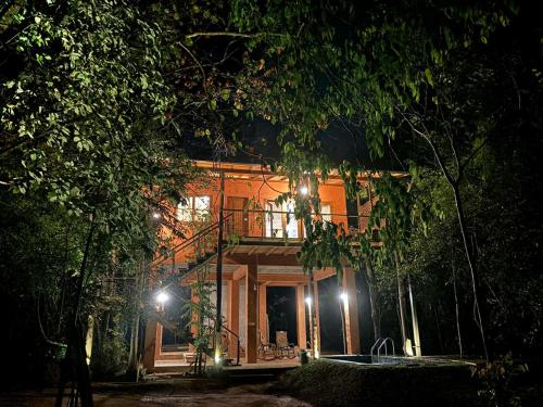 a house with a balcony on the side of it at night at Hornbill Forest Habarana in Habarana