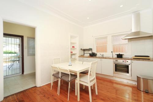 a kitchen with a table and chairs in a room at Sydney, Bexley North holiday home 3bedrooms, free parking, close to Train station and CBD in Sydney