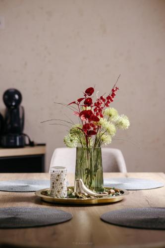 a vase with flowers in it on a table at BOROVI PRESIDENT SPA Apartment in Divčibare