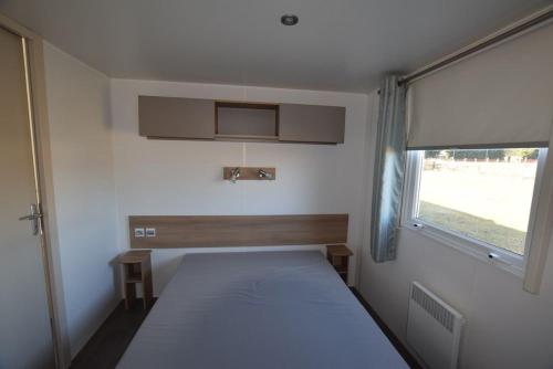 a small bedroom with a bed and a window at Mazet 13 in Vias
