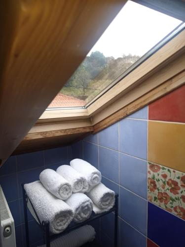 a pile of towels on a shelf under a window at Αρχοντικό Κορκόντζελου in Nafpaktos