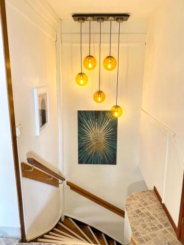 a hallway with yellow lights and a painting on the wall at Aekta Studio apartments Gothenburg in Gothenburg