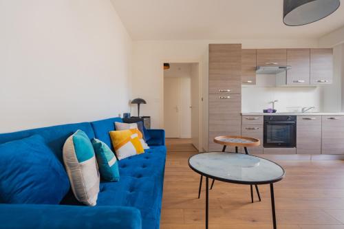 un salon avec un canapé bleu et une table dans l'établissement T2 à Ambilly avec Terrasse, Tram 17, Genève, à Ambilly