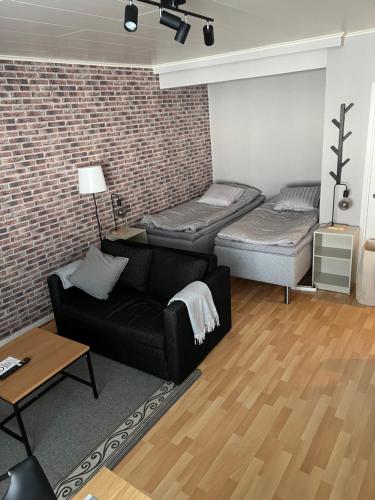 a living room with a couch and two beds at Kemi City IV, near snowcastle, premium studio, FREE private parking, Special Price! in Kemi