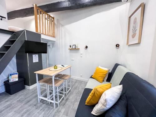 un salon avec un canapé et une table dans l'établissement L'Escapade - Charmant studio au cœur du village, à Saint-Maximin-la-Sainte-Baume