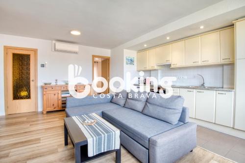 ein Wohnzimmer mit einer blauen Couch und einer Küche in der Unterkunft La Rambla in Sant Feliu de Guixols