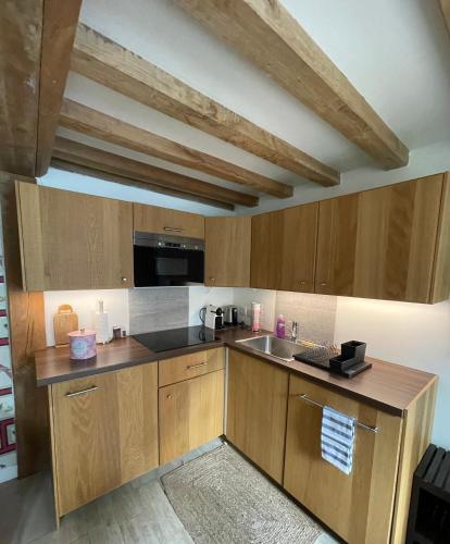 une cuisine avec des armoires en bois et un évier dans l'établissement La Casa di Nona, à Honfleur
