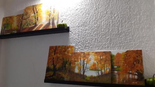 two pictures hanging on a wall with a light at Zaciszny Zakątek Zawoja in Zawoja