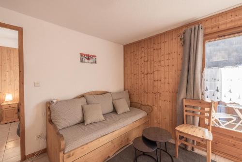 - un canapé dans une chambre avec fenêtre dans l'établissement Residence des neiges - Immoclean, à Morillon