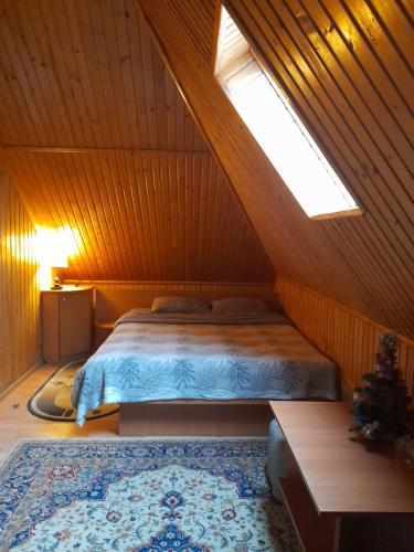 a bedroom with a bed in a wooden attic at Dlya Vseh Motel in Kamianets-Podilskyi