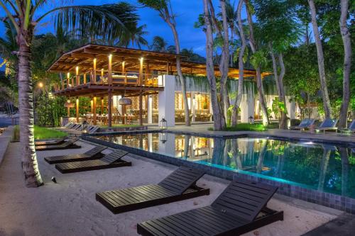 a resort with a swimming pool and a building at Jeeva Santai Villas in Senggigi 
