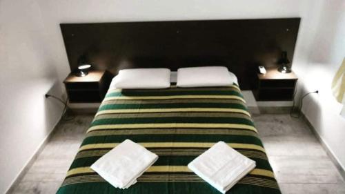 Un dormitorio con una cama grande con dos mesitas de noche. en Angará Bungalows, en Federación