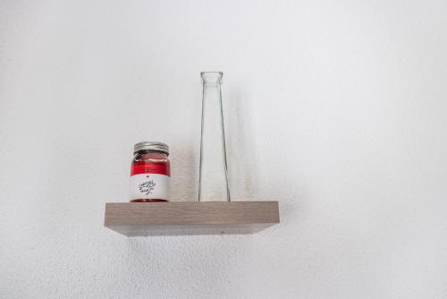 un pot en verre sur une étagère en bois avec un vase dans l'établissement Le Septimontain A28, à Samoëns