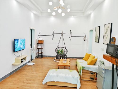 a living room with a couch and a tv at A&G Apartment in Zhangjiajie