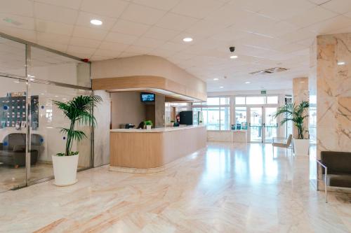 an office lobby with palm trees and a counter at Port Europa in Calpe