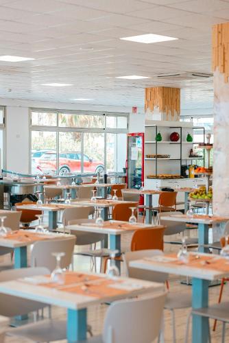 an empty restaurant with tables and chairs and windows at Port Europa in Calpe