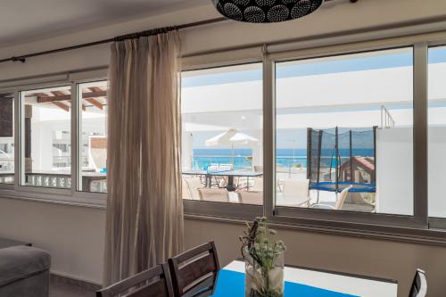 a dining room with a view of the ocean at Seafront Protaras Apartments in Protaras