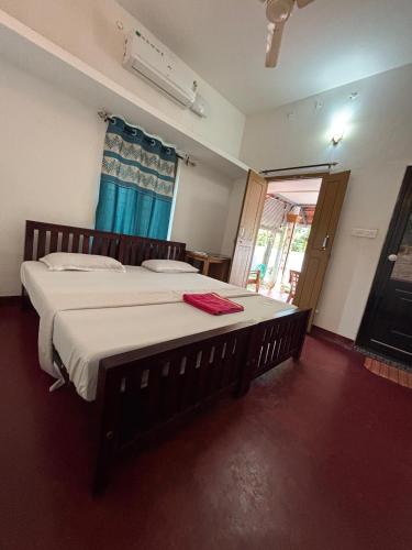 a bedroom with a large bed with white sheets at Marari diya homestay in Mararikulam