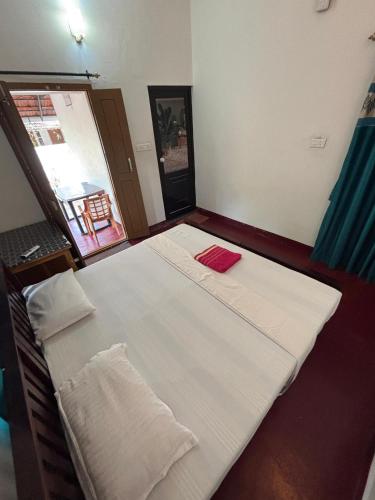 a large white bed in a room with a window at Marari diya homestay in Mararikulam