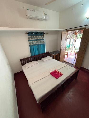 a bedroom with a large bed with white sheets and a window at Marari diya homestay in Mararikulam