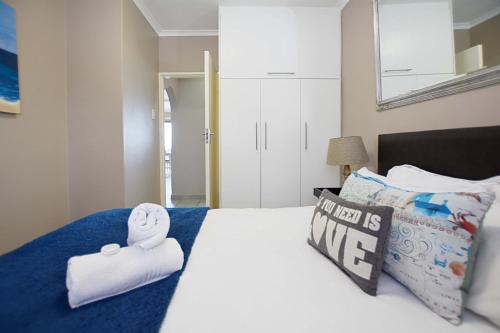 a bedroom with a bed with towels on it at Beach Daze in Bloubergstrand