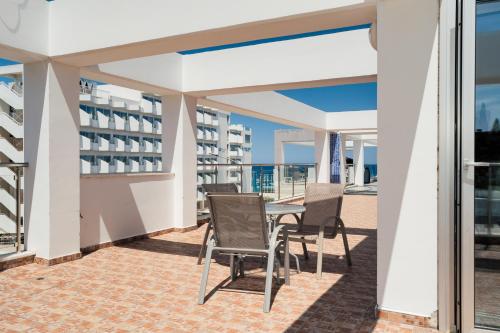 a balcony with chairs and a table on a building at Seafront Protaras Apartments in Protaras