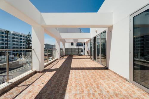 a large white building with a walkway at Seafront Protaras Apartments in Protaras