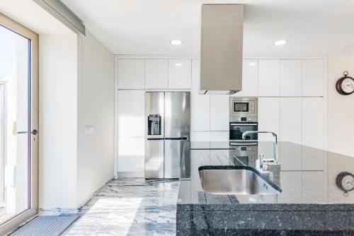 a kitchen with a sink and a stainless steel refrigerator at Villa Donana in Beiriz