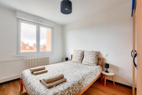 une chambre avec un lit avec deux oreillers dessus dans l'établissement Lovely 2 BR Flat with balcony near the city centre, à Strasbourg
