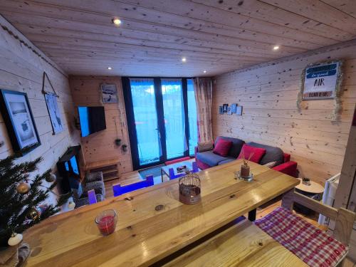 - un salon avec une grande table en bois dans une cabine dans l'établissement Charmant T2 rénové- Praloup 1600-parking privé, proche station, à Uvernet