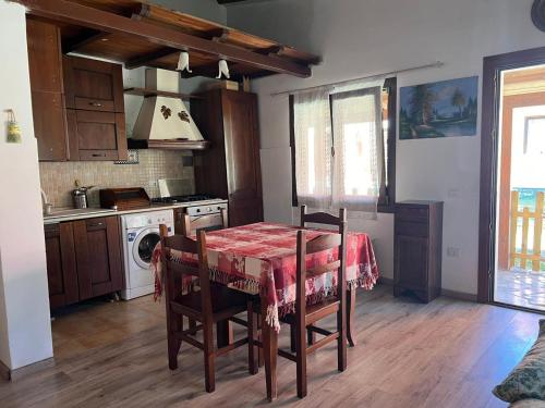 a kitchen with a table with a red table cloth at L'Orchidea in Sante Marie